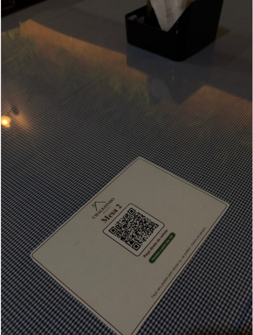 Placa com o QR Code da Mesa 2 sobre a mesa do restaurante.